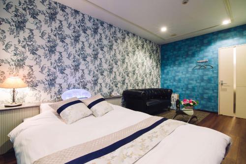 a bedroom with a bed with a blue wall at Tinkerbell (Adult Only) in Takamatsu