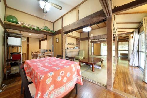 a dining room with a table and a kitchen at Kume guest house in Kumejima