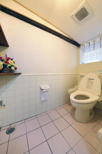 a bathroom with a toilet and a tiled floor at Kume guest house in Kumejima