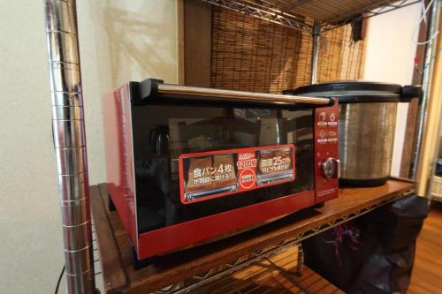 a microwave oven sitting on a shelf in a kitchen at Kume guest house in Kumejima