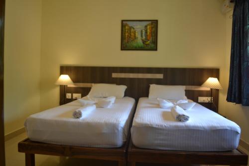 2 łóżka w pokoju hotelowym z białą pościelą w obiekcie The Majorda Pristinne w mieście Majorda