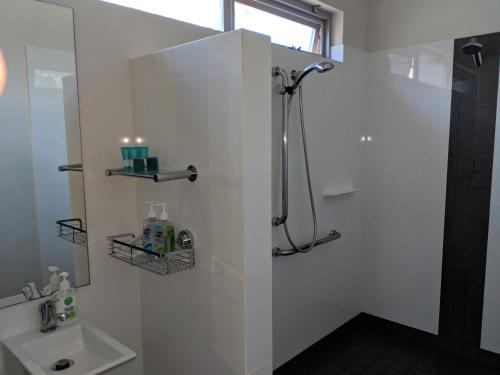 a white bathroom with a shower and a sink at Hanover Bay Apartments in Albany