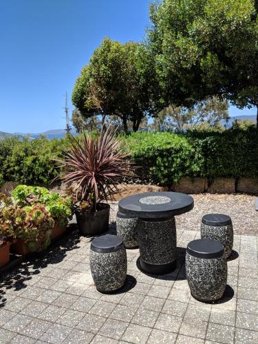 a picnic table and four stools in a garden at Hanover Bay Apartments in Albany