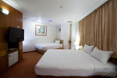 Ένα ή περισσότερα κρεβάτια σε δωμάτιο στο Hara Zuru Hotel