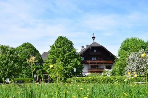 a house in the middle of a field with trees at Seehotel Huber in Sankt Gilgen
