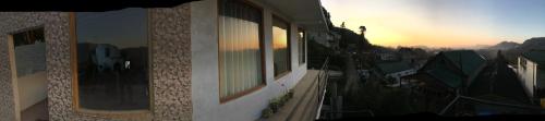 a building with windows with the sunset in the background at Golden King Guest in Nuwara Eliya