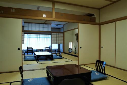 a living room with a table and chairs at Grandia Housen in Awara