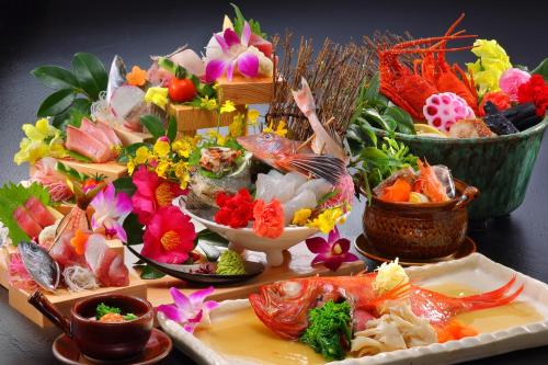 a table with plates of food and bowls of flowers at Hanashibuki in Tateyama