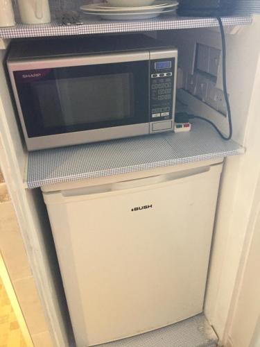 a microwave oven sitting on top of a refrigerator at Clinton's Green B&B in Bracknell