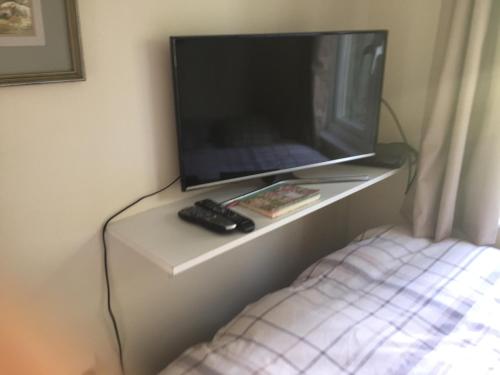 a tv sitting on a table with a remote control at Clinton's Green B&B in Bracknell
