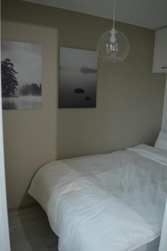 um quarto com uma cama branca e uma fotografia na parede em Aurora Haven Rovaniemi Modern DT Apartment -Self Check-In & Free Wifi- em Rovaniemi