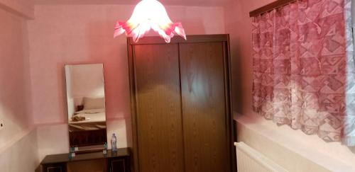 ein Badezimmer mit einem Holzschrank mit einer Lampe darüber in der Unterkunft Little Star in Kazbegi