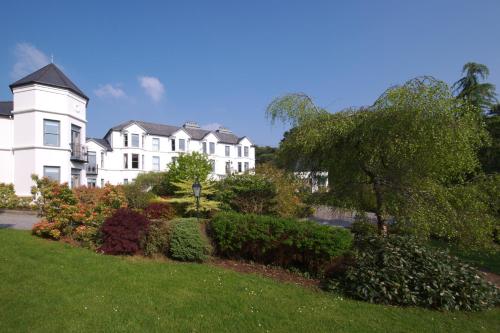 a large white house with a garden in front of it at Seaview House Hotel in Bantry