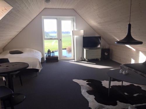 a bedroom with a bed and a large window at Holmens Guesthouse in Lemming