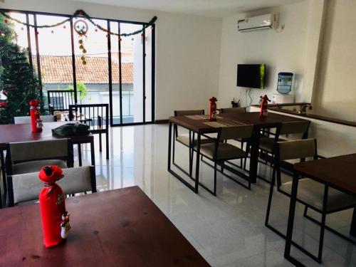 a dining room with tables and chairs and a tv at Visakha 6 in Colombo