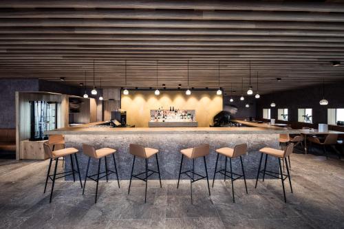 a bar with stools in front of a counter at Hotel Lamm in Castelrotto
