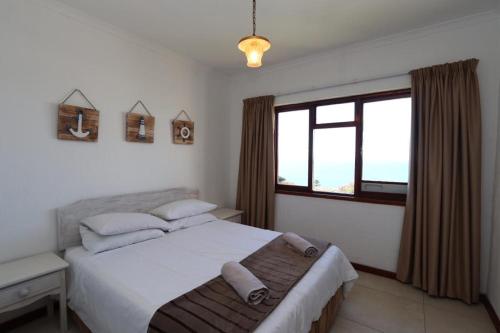 普利登堡灣的住宿－Villa Granada，一间卧室设有一张大床和一个窗户。