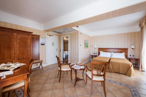 a bedroom with a bed and a table and chairs at Dioscuri Bay Palace in San Leone