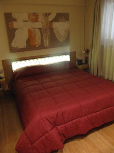 a bedroom with a red bed with a red blanket at Mario's Garni in Pescocostanzo
