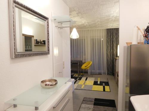 une cuisine blanche avec un miroir et une chaise jaune dans l'établissement Ferienwohnung Schwarzwaldrauschen, à Schönwald