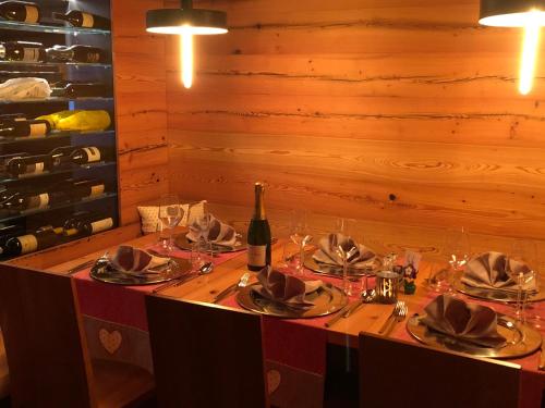 a table with a bottle of wine and glasses at Hotel Silvana in Selva di Val Gardena