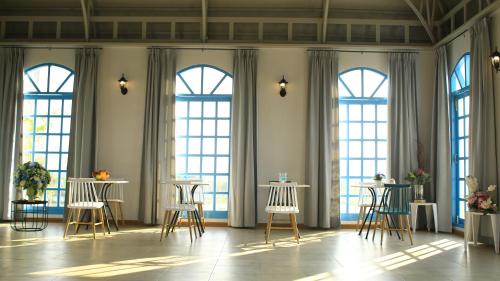 a room with tables and chairs in front of windows at The Lake Udon in Udon Thani