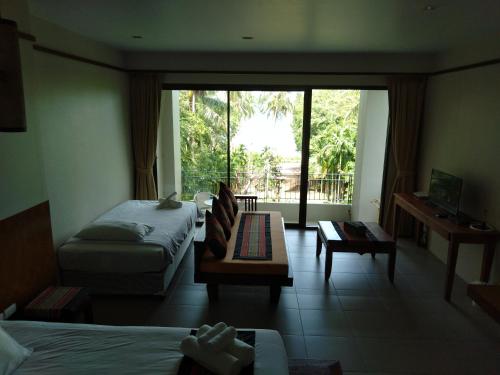 a hotel room with two beds and a window at C-VIEW BOUTIQUE in Rawai Beach