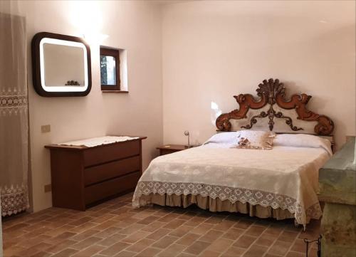 1 dormitorio con cama, tocador y espejo en Nel Chianti lungo la Francigena, en Colle Val D'Elsa