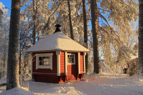 a small building in the snow in a forest at Maatilamatkailu Jänisvaara in Kolinkylä