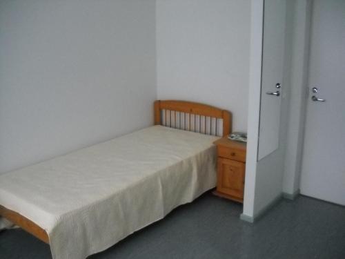 um pequeno quarto com uma cama e uma cómoda em madeira em Saaremäe em Otepää