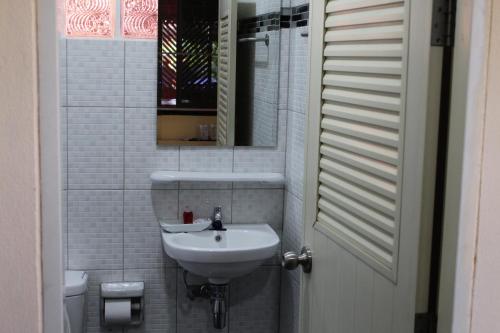 a white bathroom with a sink and a mirror at Phuphet Hill Resort in Phu Ruea