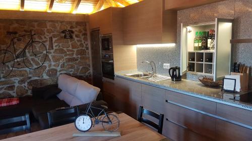 a kitchen with a counter and a table with a clock at Bicycle House in Felgueiras