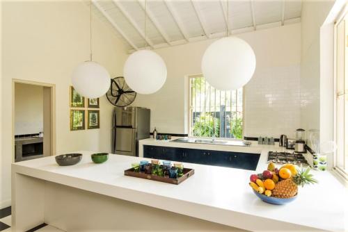 a kitchen with a counter with a bowl of fruit on it at Monara House, Talpe in Unawatuna