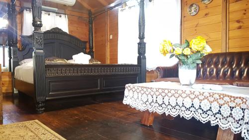 a bedroom with a bed and a table with a vase of flowers at Lake Mansion in Tiberias