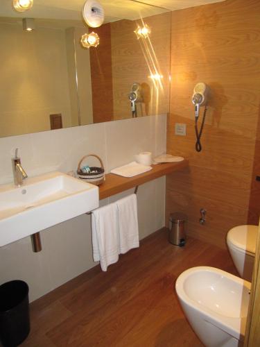 a bathroom with a sink and a toilet and a mirror at Mario's Garni in Pescocostanzo