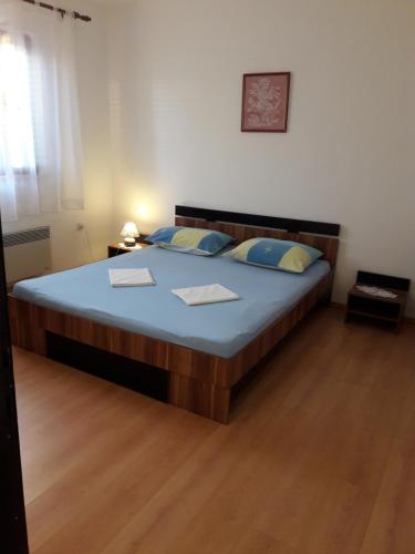 ein Schlafzimmer mit einem großen Bett mit blauer Bettwäsche und blauen Kissen in der Unterkunft Apartmani Dokoza in Drage
