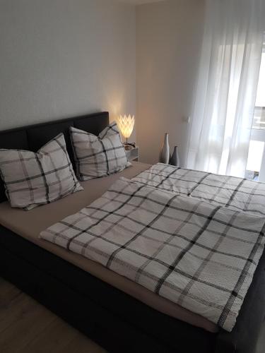 a bed with a plaid blanket and pillows in a bedroom at Ferienwohnung Moritz in Sankt Aldegund