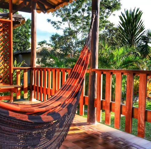 a hammock on a deck with a wooden fence at Pousada Cachoeira Poço Encantado in Alto Paraíso de Goiás