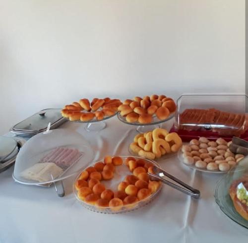 a table with plates of pastries and other foods at Pousada Cachoeira Poço Encantado in Alto Paraíso de Goiás
