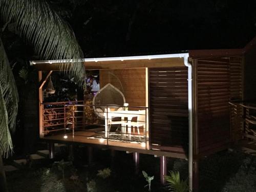 a small cabin with a table and chairs on a deck at Charmant bungalow au cœur de l’île in Baie-Mahault