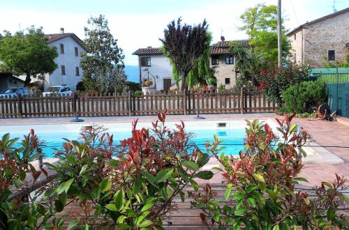 een zwembad in een tuin met een hek bij Podere Casenove in Citerna