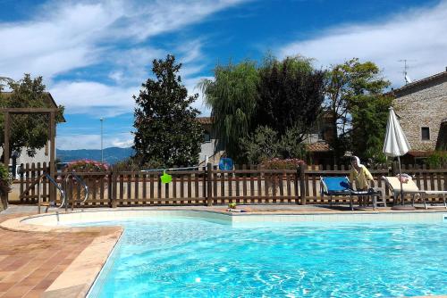 een groot zwembad met een houten hek ernaast bij Podere Casenove in Citerna