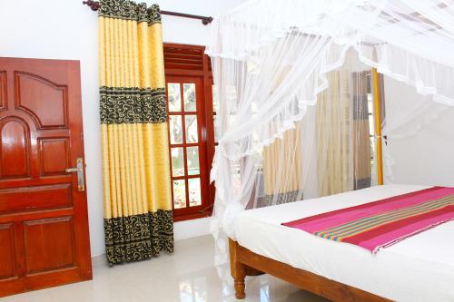 a bedroom with a bed and a window at Pradeep Guest House in Mirissa