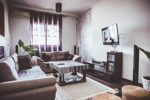 un soggiorno con divano e TV di Home sweet home a El Aouina