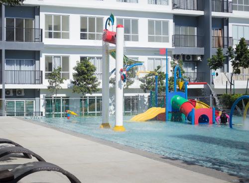 a pool with a water park in front of a building at BSP21 in Jenjarum