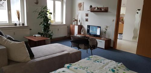 sala de estar con sofá y escritorio con ordenador en FeWo im Herzen Reichenbachs, en Reichenbach im Vogtland