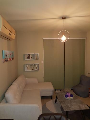 a living room with a white couch and a table at Ria Court 33 in Larnaka
