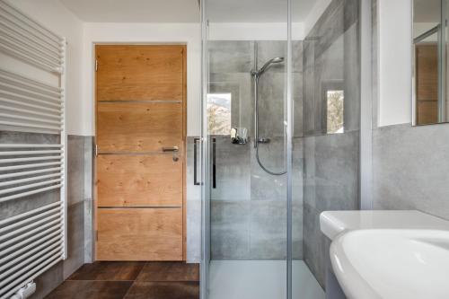 baño con ducha y puerta de cristal en Apartments San Vigilio, en San Vigilio Di Marebbe