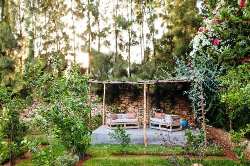 un jardín con cenador y banco en La Maison des Ailleurs, en Essaouira