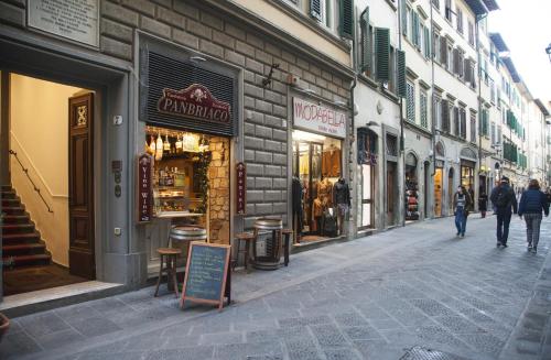 フィレンツェにあるホテル アカデミアの通りを歩く人々やお店が並ぶ通り